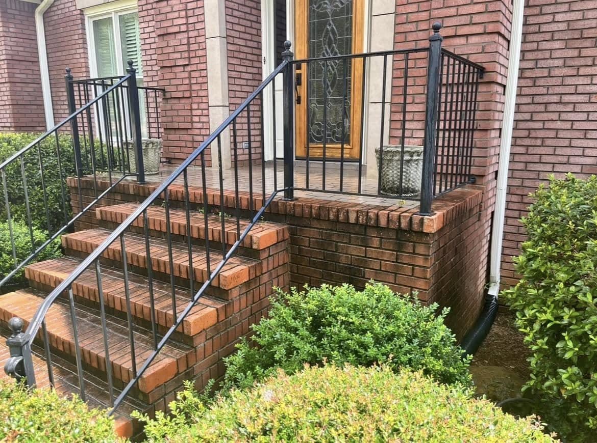 Brick front steps and iron rails dark with buildup before a house wash, Birmingham metro