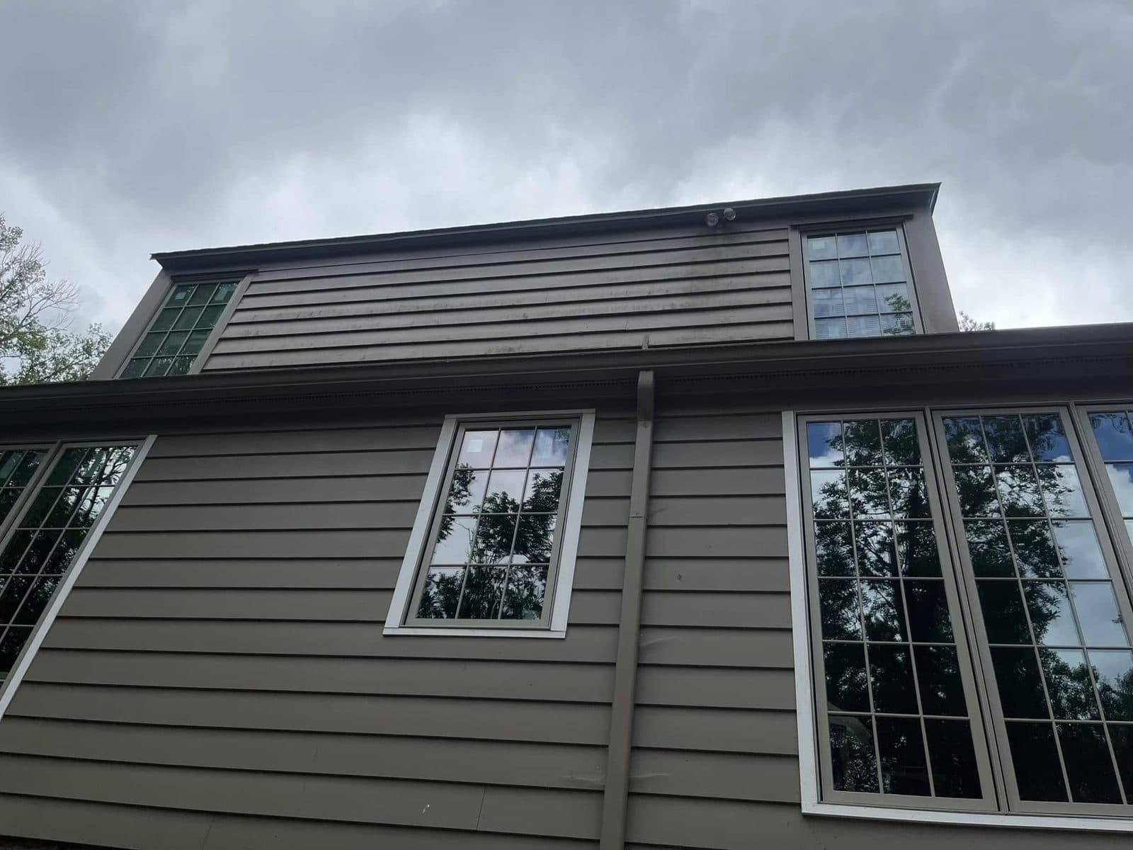 Grey lap siding and white windows after a house wash, Birmingham metro